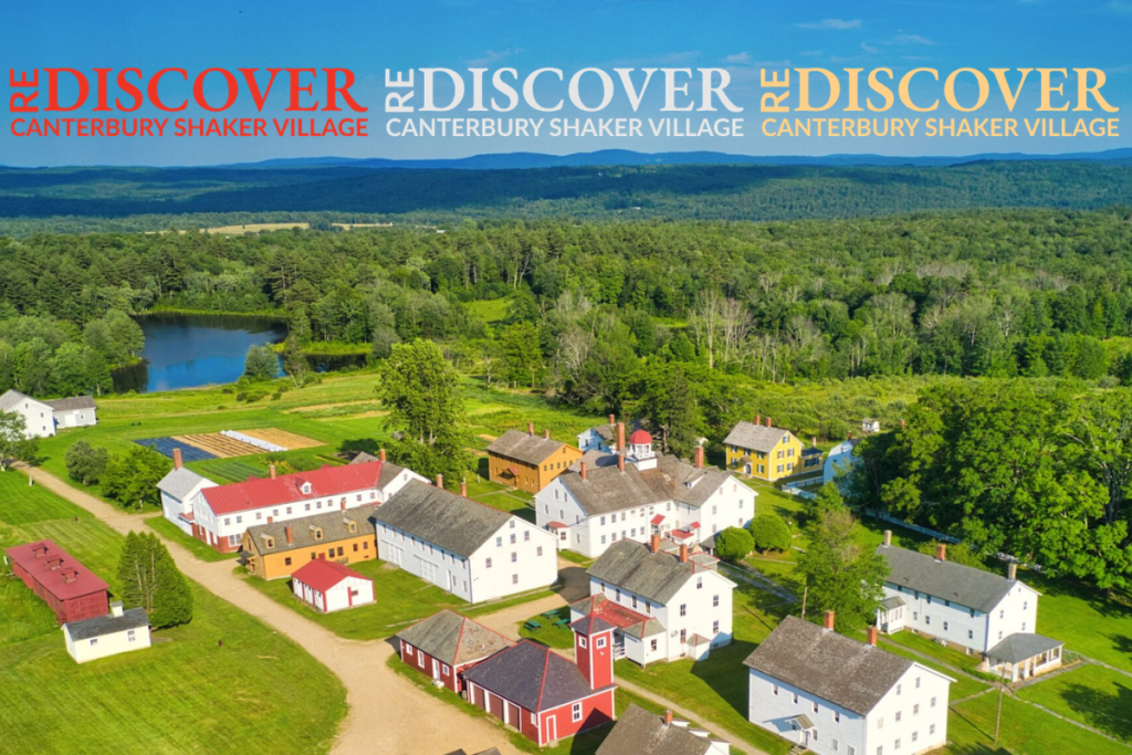 Aerial view of a colorful Shaker village with white, red, and yellow houses and green fields beneath a blue sky, with the word DISCOVER repeated across the top as a banner.